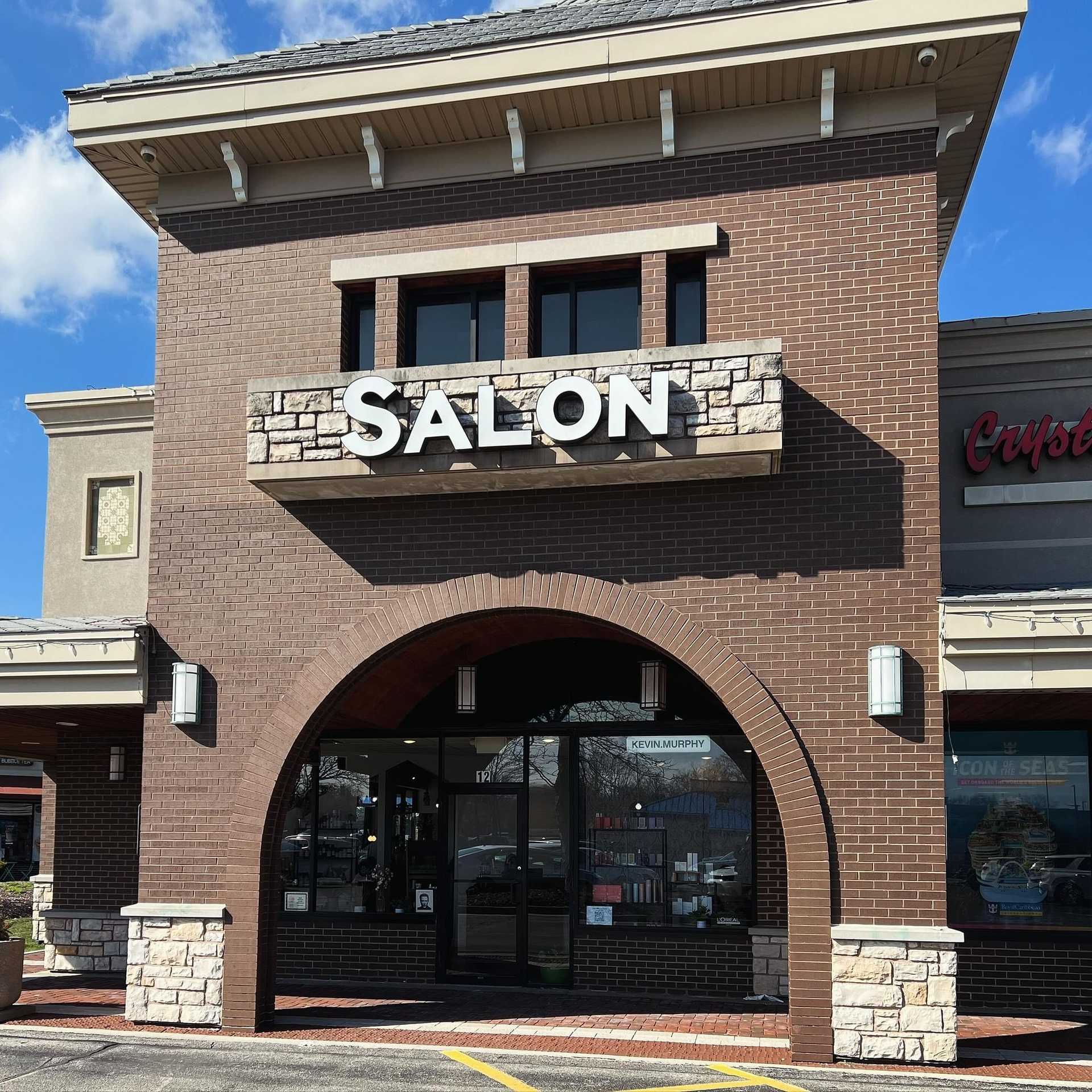 Exterior of a modern brick building with a large sign reading "Salon" above the entrance.